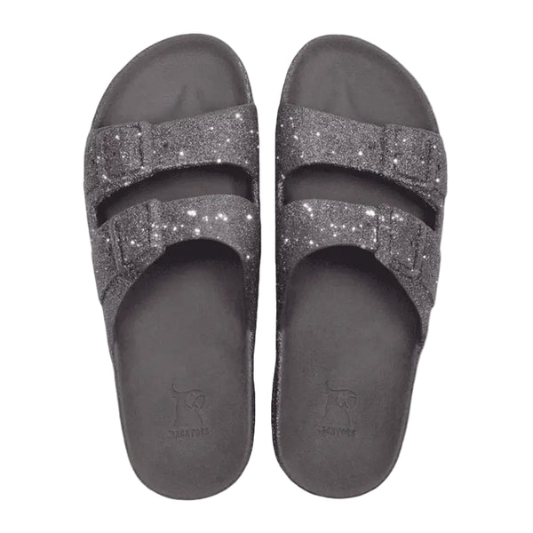 Pair of gray glittery slide sandals on a white background