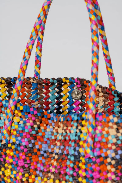 Multicolored woven handbag with a plain background
