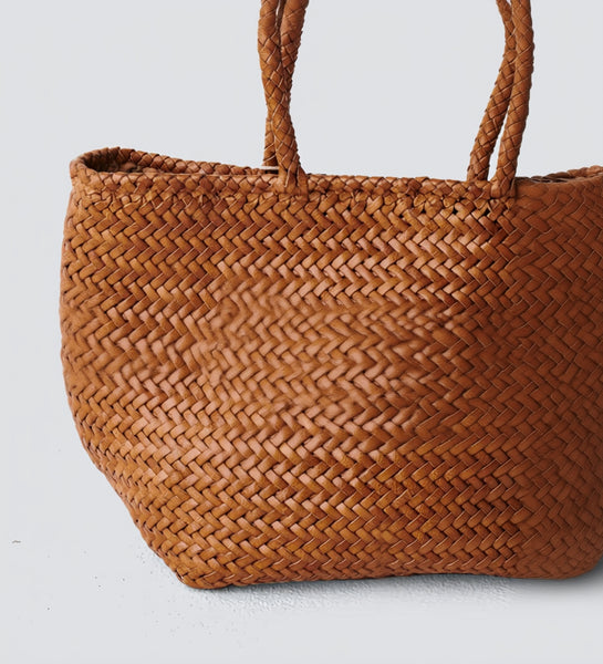 Brown woven handbag on a light gray background