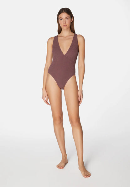 Woman wearing a brown swimsuit on a white background