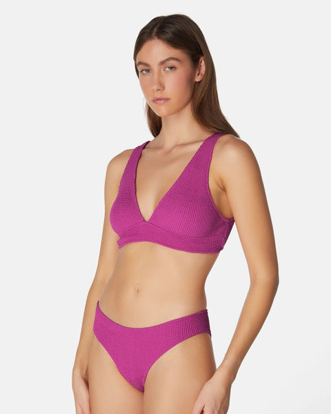 Woman wearing a purple bikini set on a white background