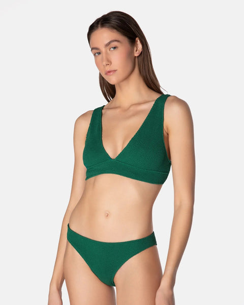 Woman wearing a green bikini set on a white background