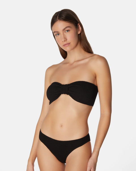Woman wearing a black strapless bikini on a white background