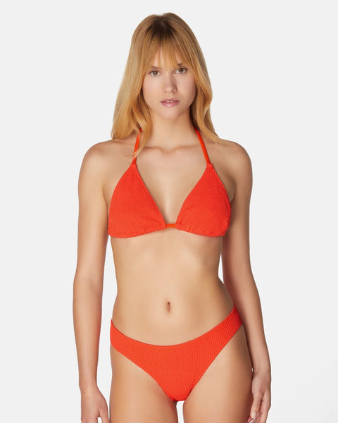 Woman wearing a red bikini against a white background