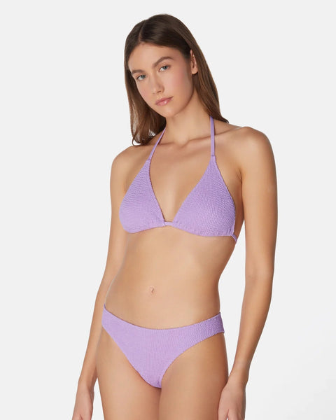 Woman wearing a purple bikini set on a white background