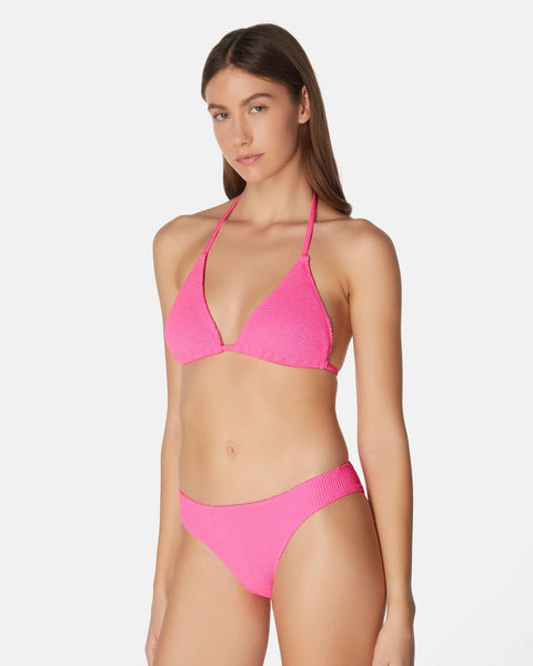 Woman wearing a pink bikini set on a white background