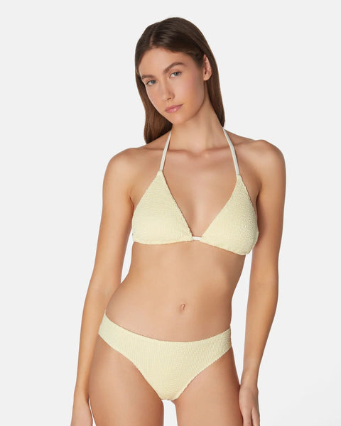 Woman wearing a light yellow bikini set on a white background
