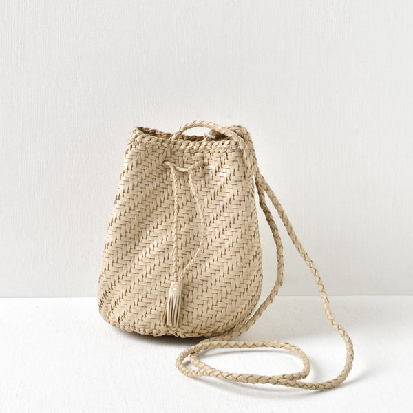 Woven straw bag with a drawstring on a white background