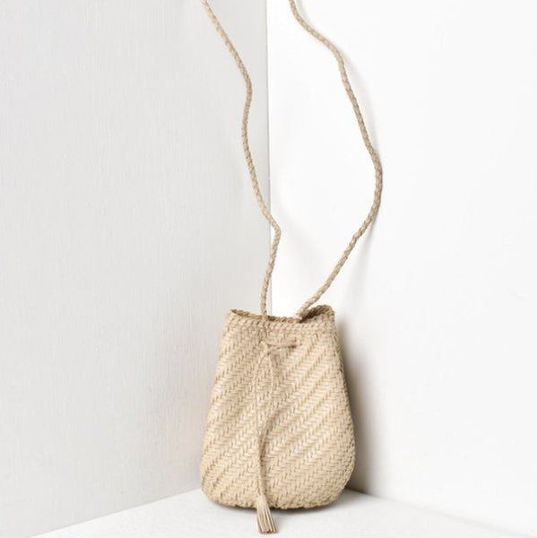 Woven handbag with a long strap on a white background